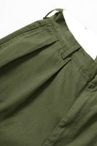 Close-up detail of Service Works Drill Part Timer shorts in olive showing fabric and pleated construction