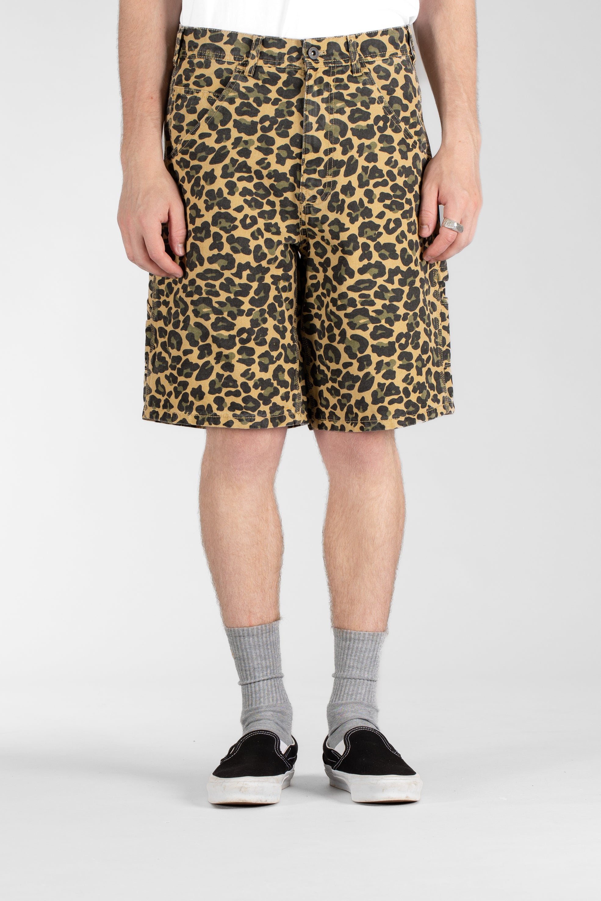 Front view of model wearing Stan Ray Big Job Short Leopard Camo oversized painter shorts with utility pockets and relaxed relaxed fit.