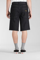 Side view of model wearing Stan Ray Wide 5 Short Charcoal Denim made from heavyweight cotton denim with relaxed wide-leg fit.