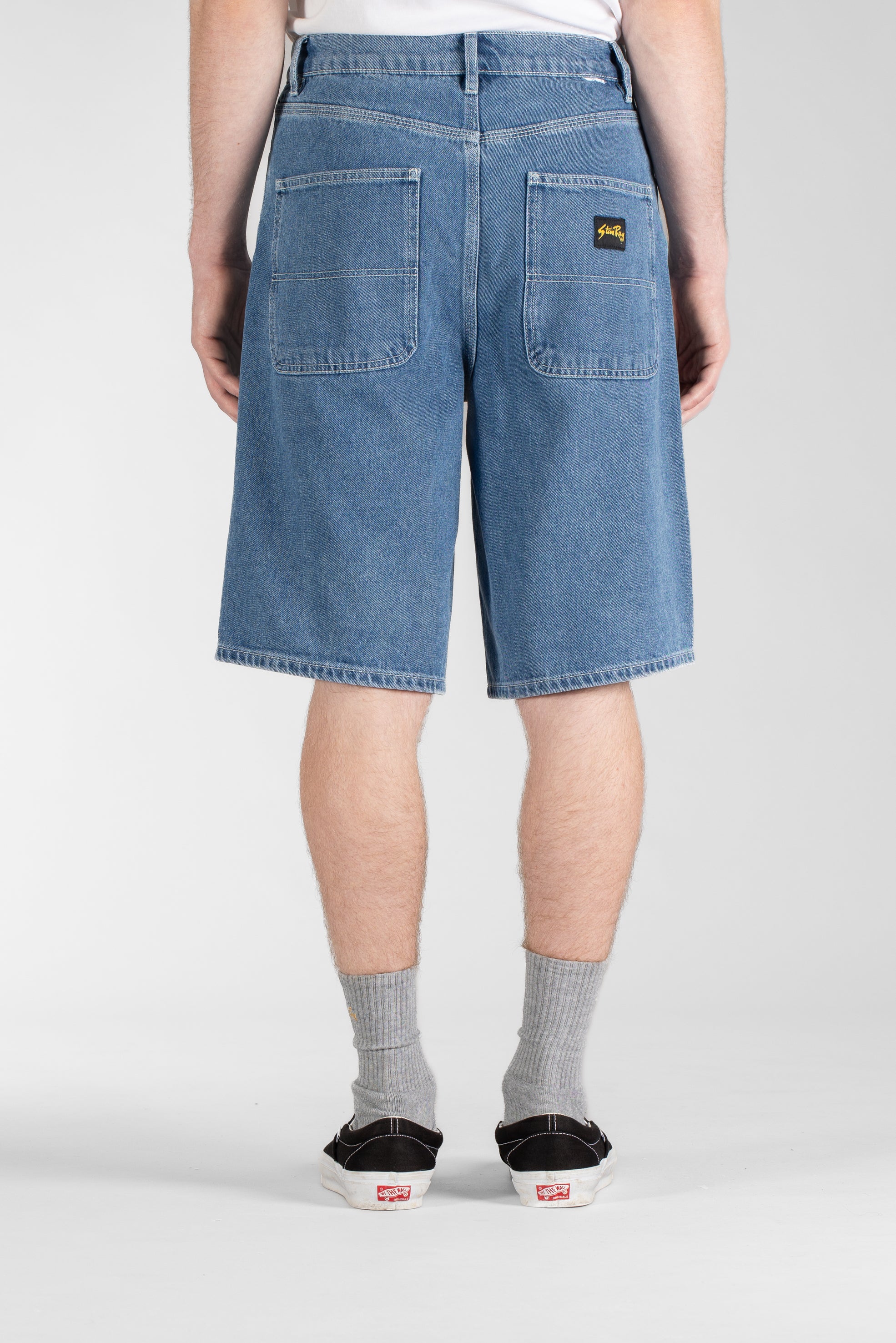 Side view of model wearing Stan Ray Wide 5 Short Mid Stone Denim made from heavyweight cotton denim with relaxed loose fit and classic workwear style.
