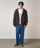 Front view of model wearing light wash relaxed fit denim jeans with roomy silhouette and eco-cotton fabric