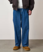 Model wearing light wash relaxed fit denim jeans with eco-cotton fabric, elastic waistband and comfortable everyday styling