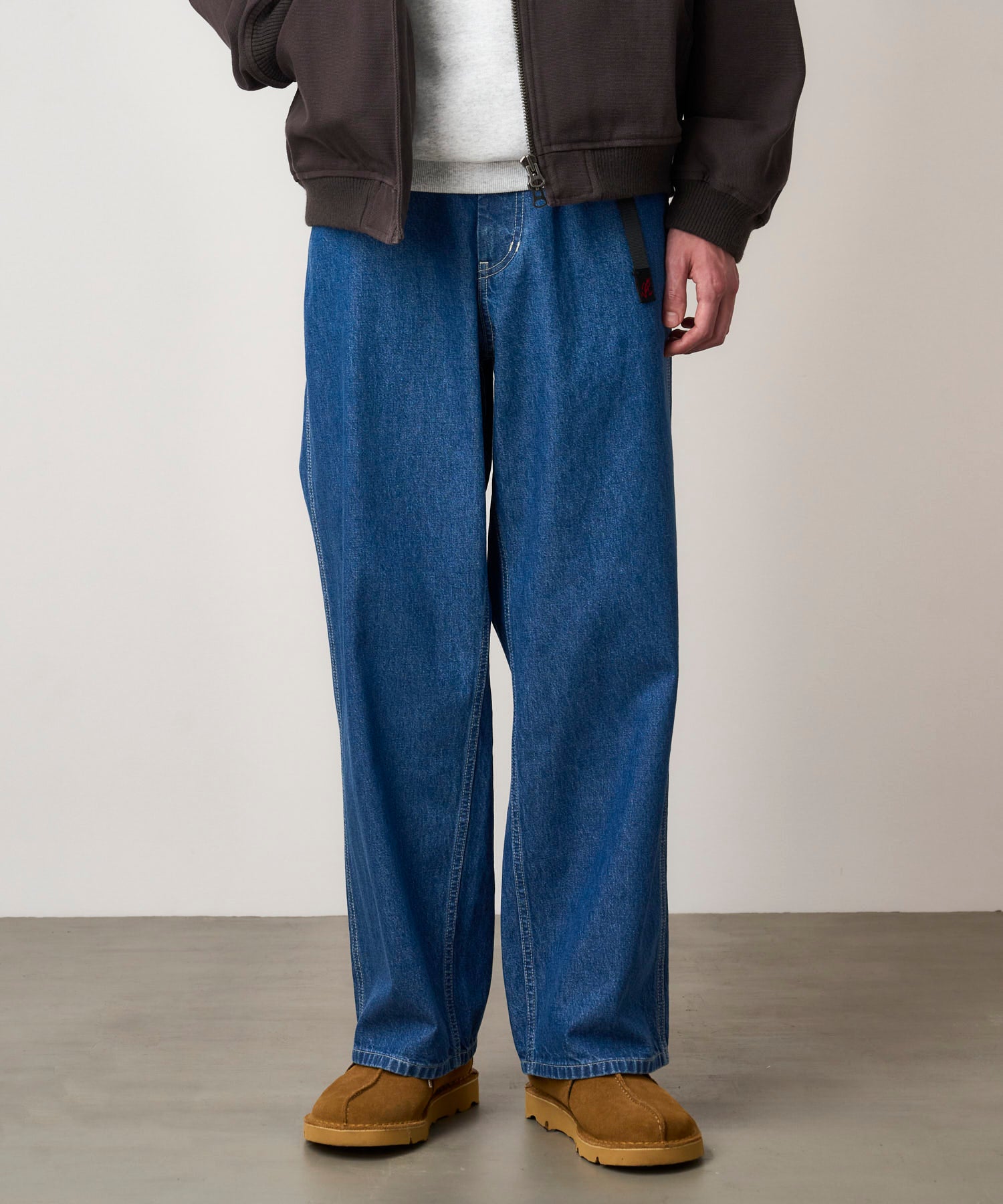 Model wearing light wash relaxed fit denim jeans with eco-cotton fabric, elastic waistband and comfortable everyday styling