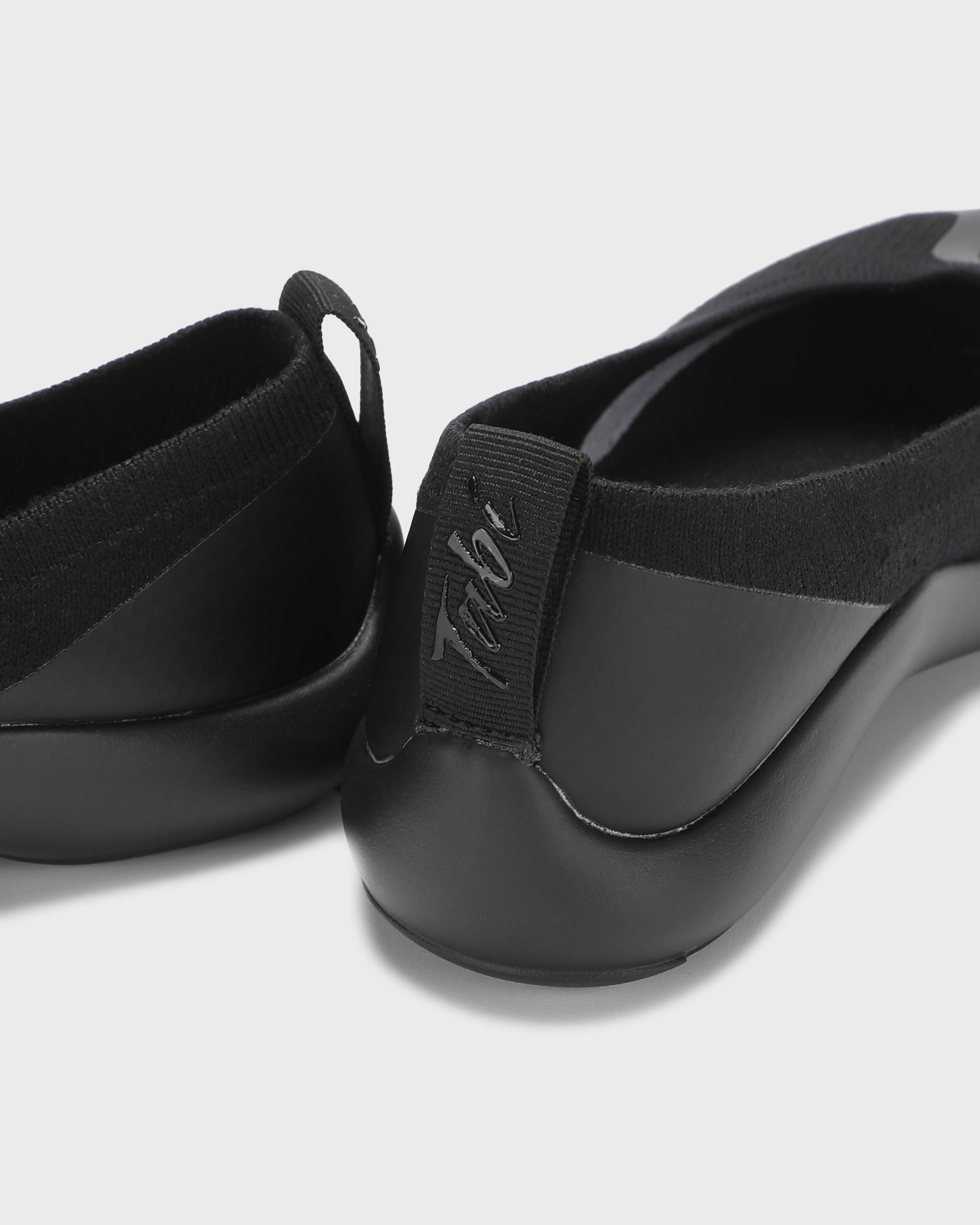 Close-up back view of black Tabi Ballerina shoes showing heel and knit upper detail