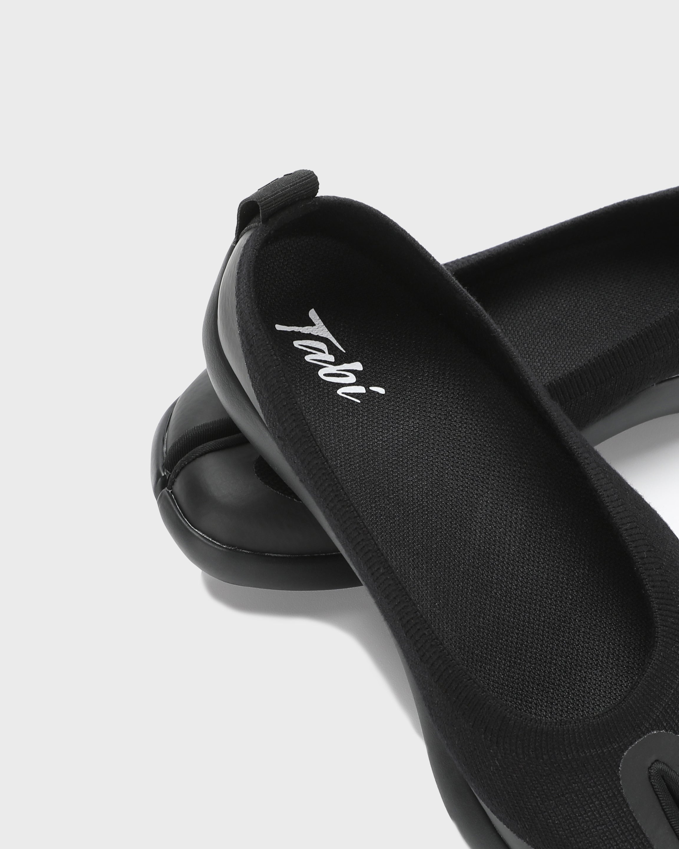 Close-up of the logo detail on black Tabi Ballerina shoes
