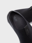 Close-up detail of Tabi Mules Black showing brand logo, split-toe knit upper and premium lightweight construction.