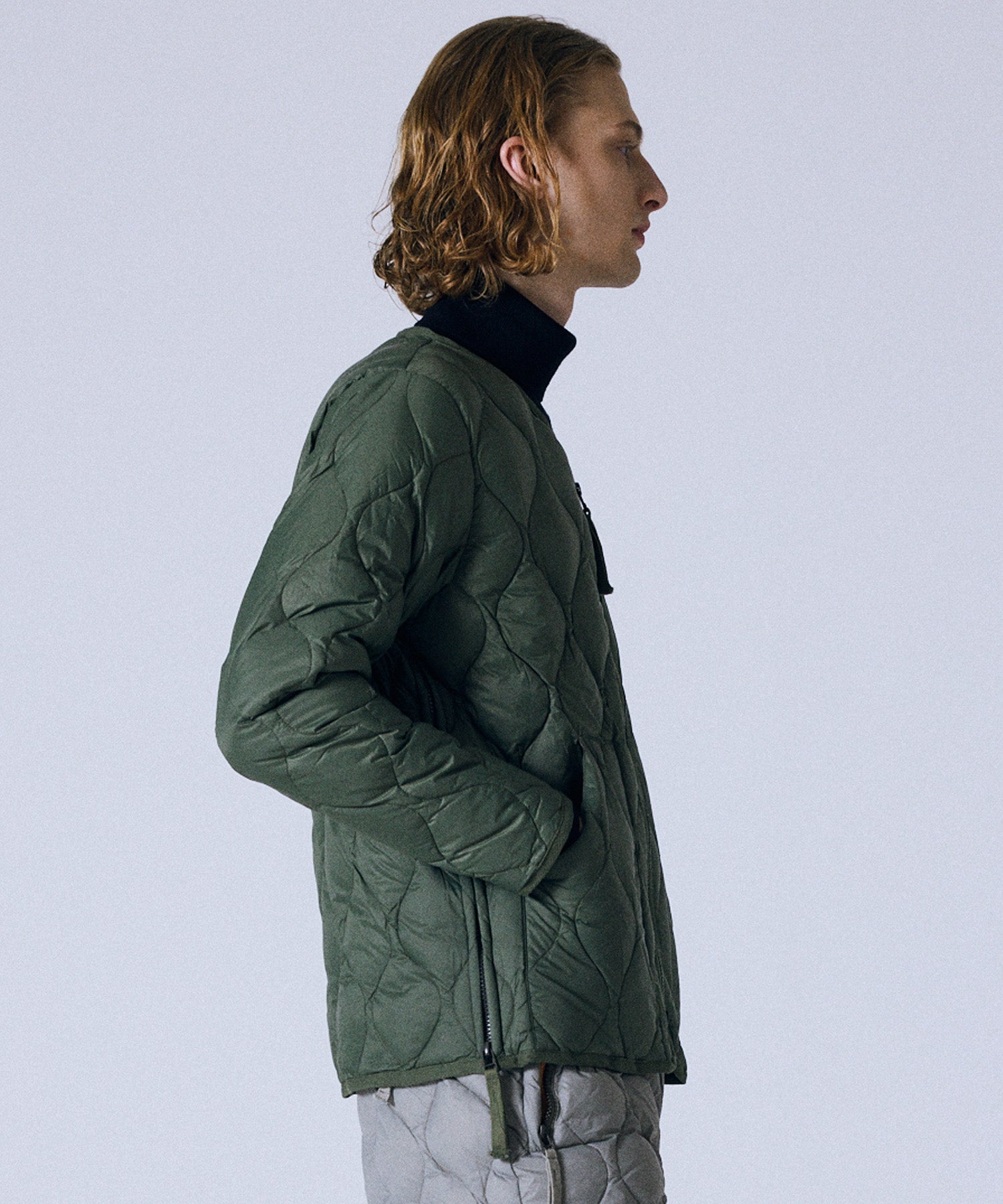 Model wearing Taion Military V Neck W-Zip Down Jacket in Olive with lightweight insulated soft-shell design for everyday wear