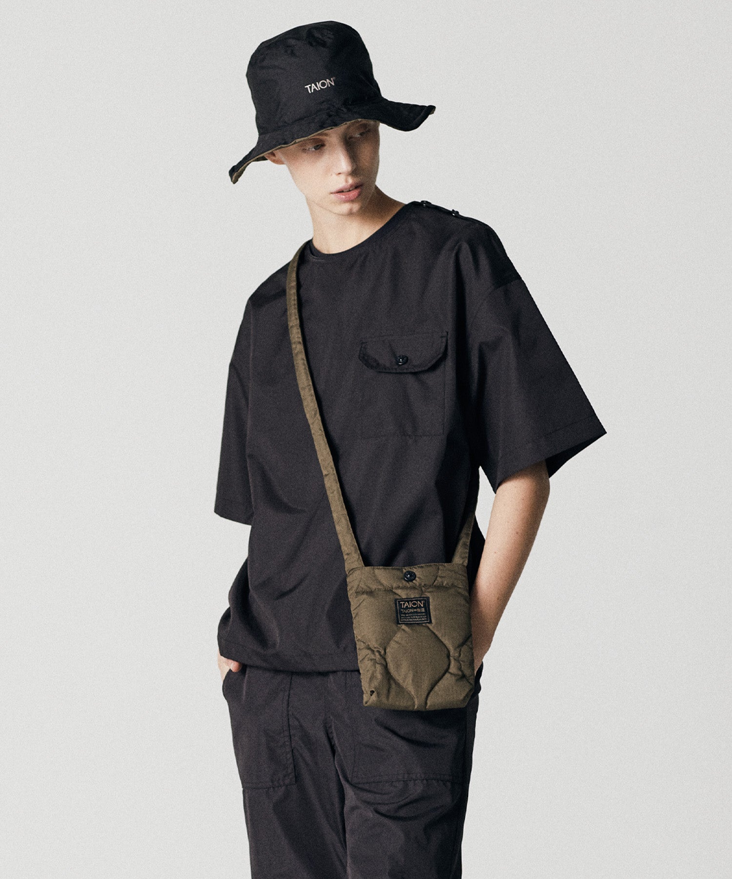 Taion Non Down Military Half Sleeve Cut Sew in Black with lightweight stain-resistant fabric and relaxed everyday comfort
