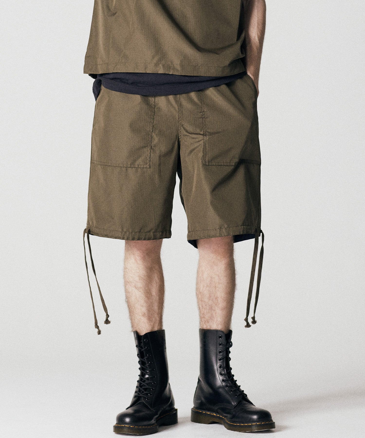 Model wearing Taion Non Down Military Reversible Shorts in Dark Olive