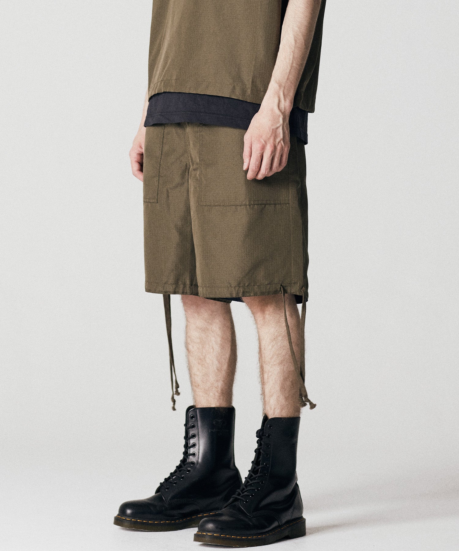 Model wearing Taion Non Down Military Reversible Shorts in Dark Olive with a relaxed fit for everyday wear