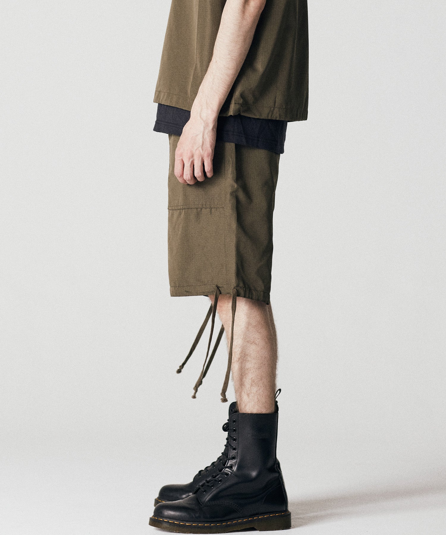 Model wearing Taion Non Down Military Reversible Shorts in Dark Olive for versatile everyday comfort