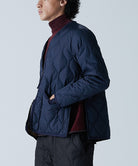 Model wearing Taion Unisex Military Zip V Neck Down Jacket in D.Navy
